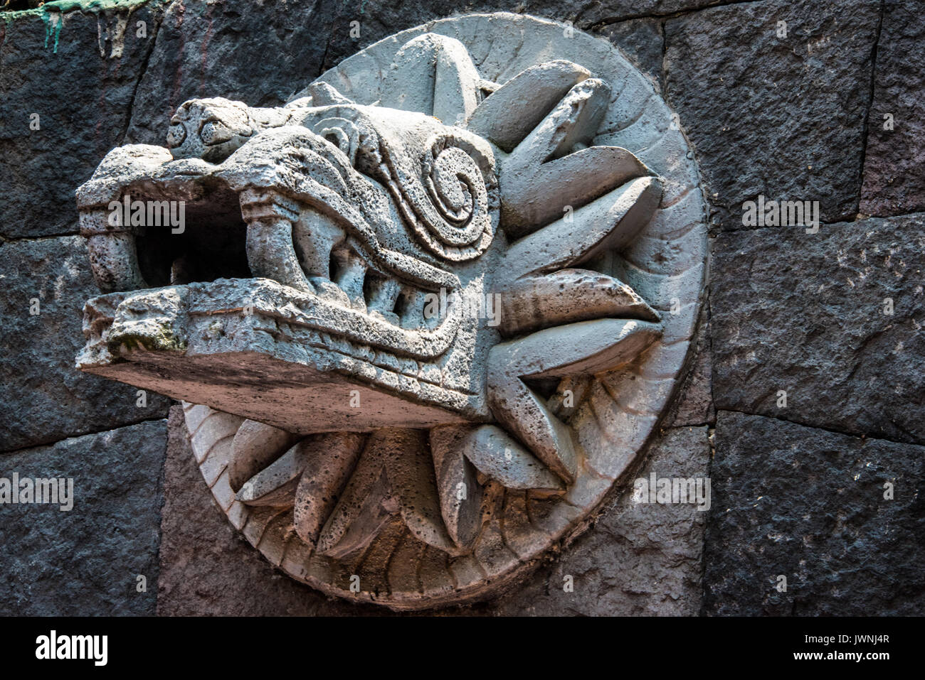 Old stone carving di Quetzalcoatl l antico serpente piumato Dio azteco montato su una parete di pietra in Messico Foto Stock