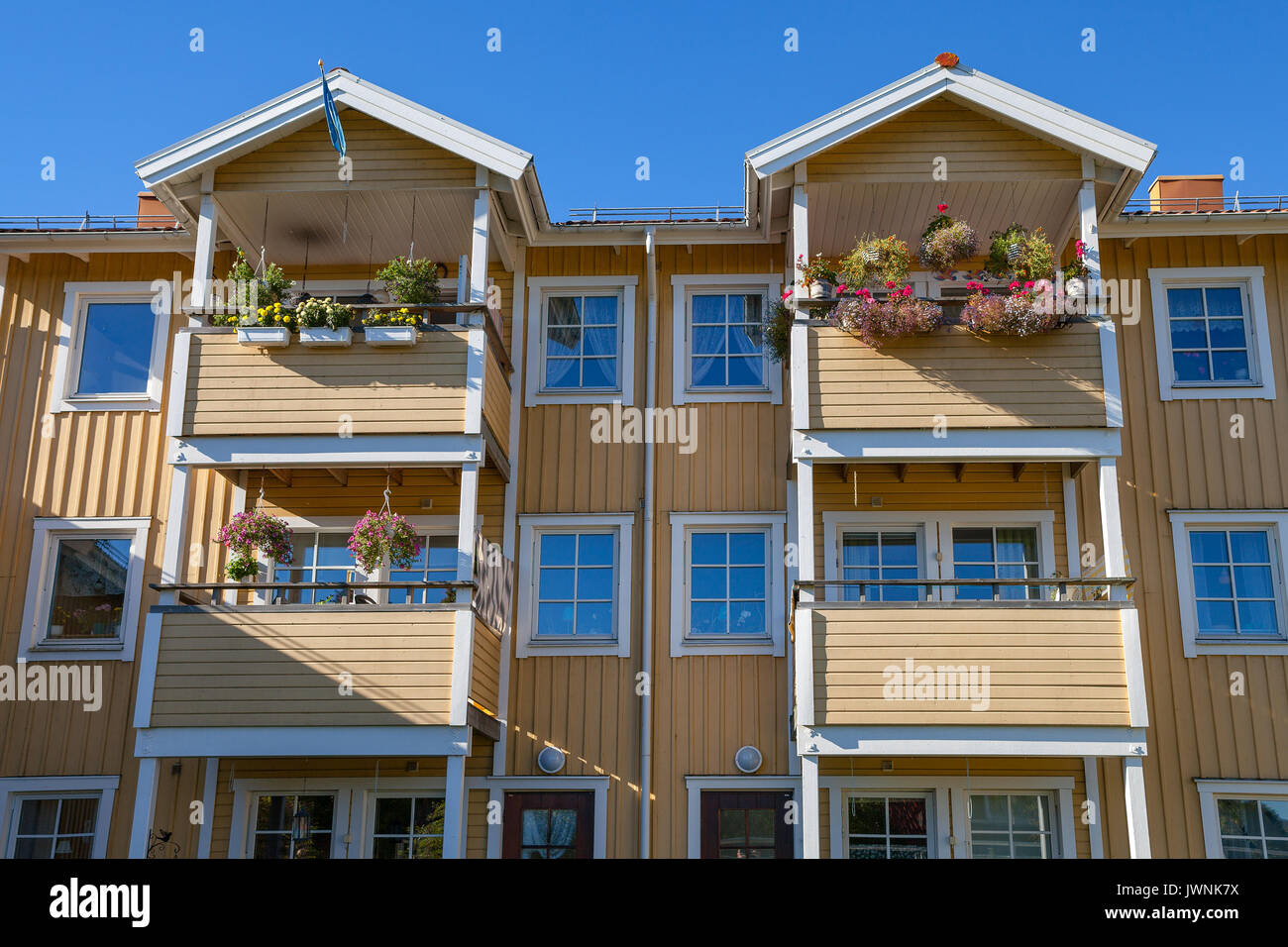 Moderna casa in legno (blocco) con balconi e fiori Foto Stock