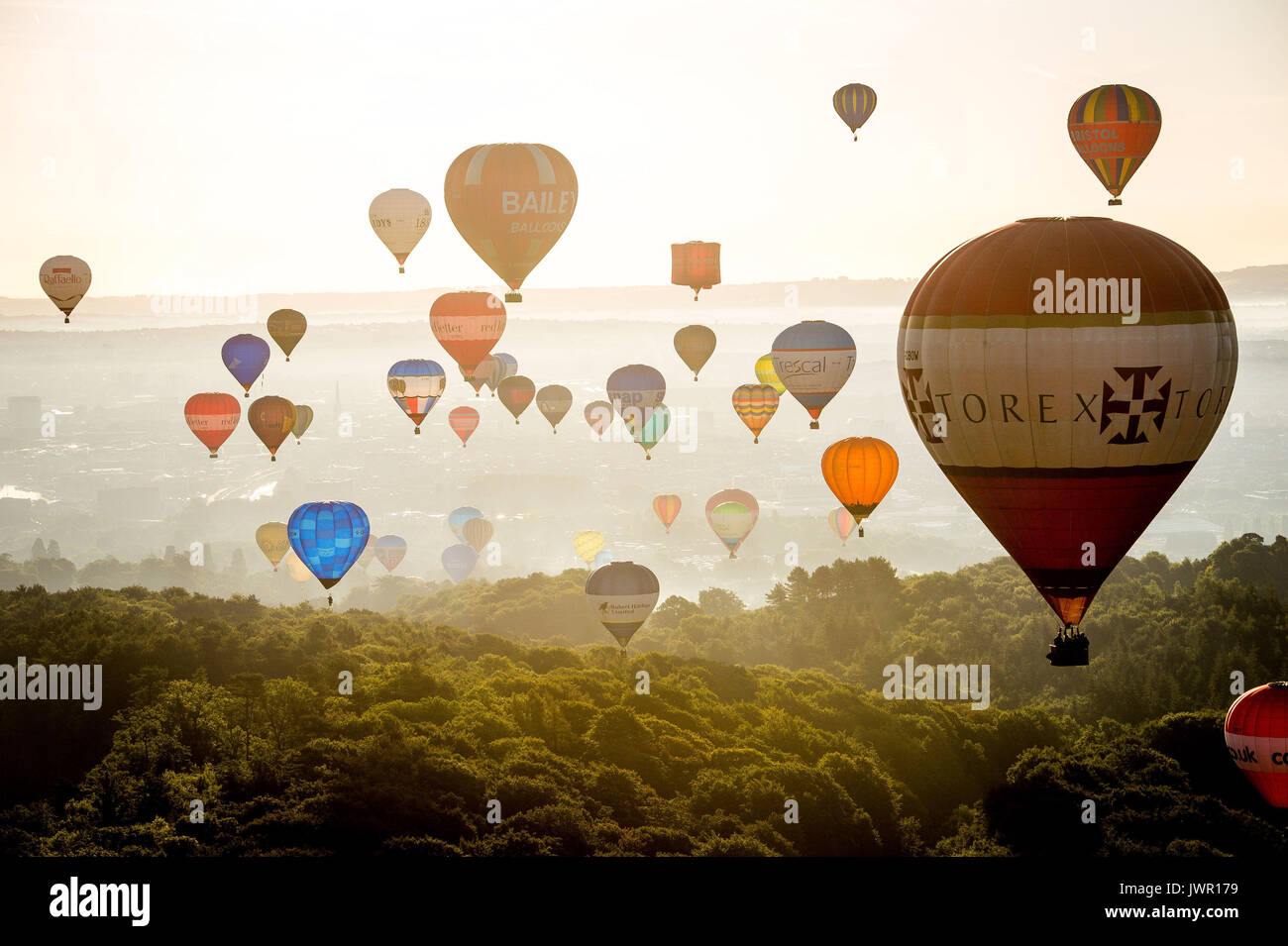 I palloni ad aria calda sopra Long Ashton sorvolare Bristol durante la salita di massa, dove mongolfiere provenienti da tutto il mondo si riuniranno a Ashton Court, Bristol, a prendere parte al Bristol International Balloon Fiesta. Foto Stock
