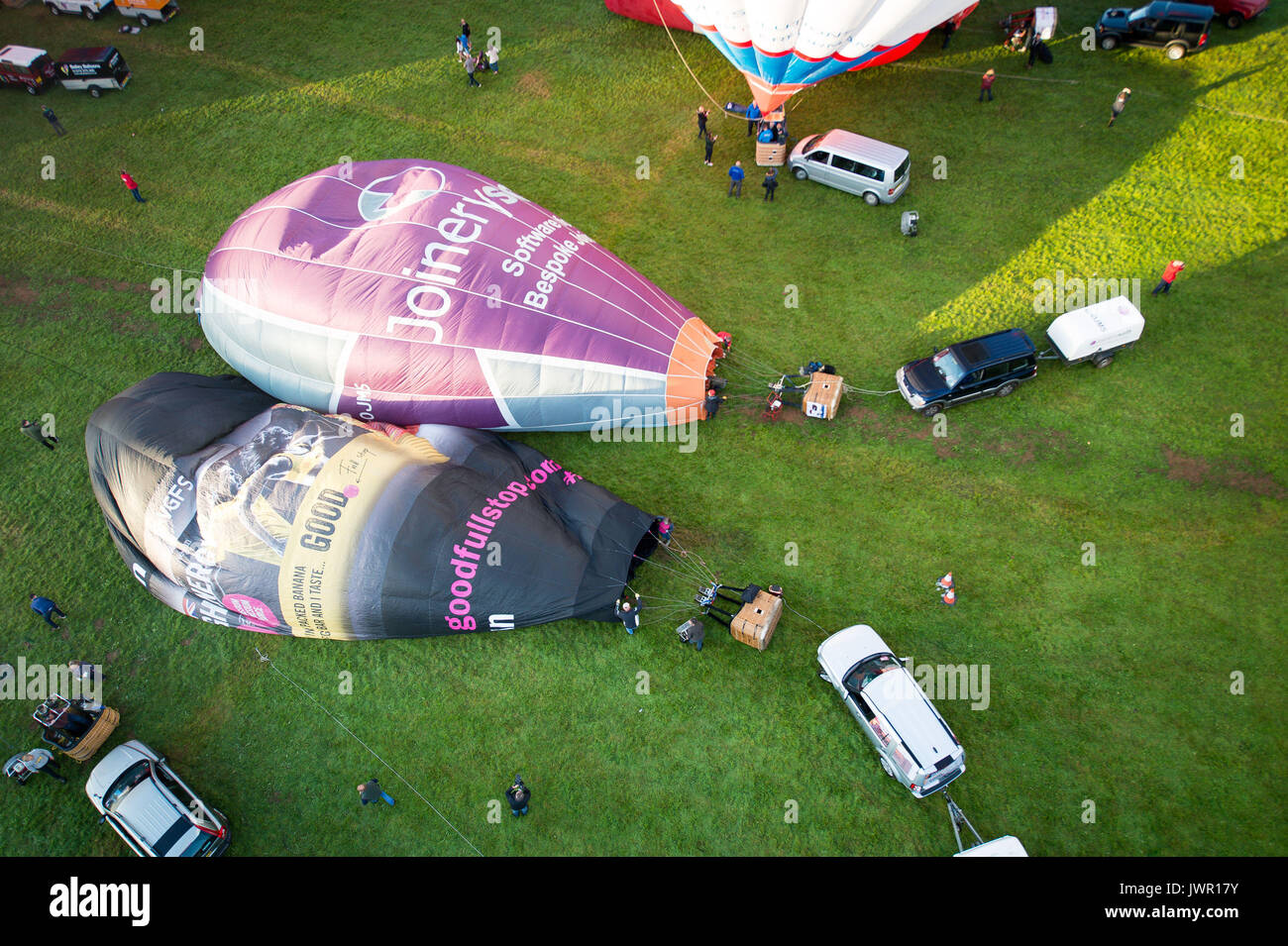 I palloni ad aria calda iniziano a gonfiare sul sito di lancio durante la salita di massa, dove mongolfiere provenienti da tutto il mondo si riuniranno a Ashton Court, Bristol, a prendere parte al Bristol International Balloon Fiesta. Foto Stock
