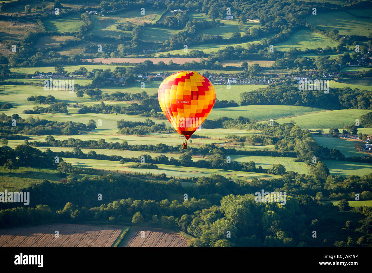 Una mongolfiera derive attraverso Somerset campagna durante la salita di massa, dove mongolfiere provenienti da tutto il mondo si riuniranno a Ashton Court, Bristol, a prendere parte al Bristol International Balloon Fiesta. Foto Stock