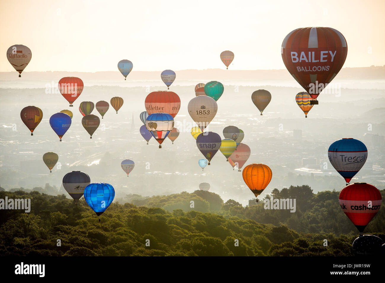 I palloni ad aria calda passa il puntatore del mouse su Long Ashton, Bristol, durante la salita di massa, dove mongolfiere provenienti da tutto il mondo si riuniranno a Ashton Court, Bristol, a prendere parte al Bristol International Balloon Fiesta. Foto Stock
