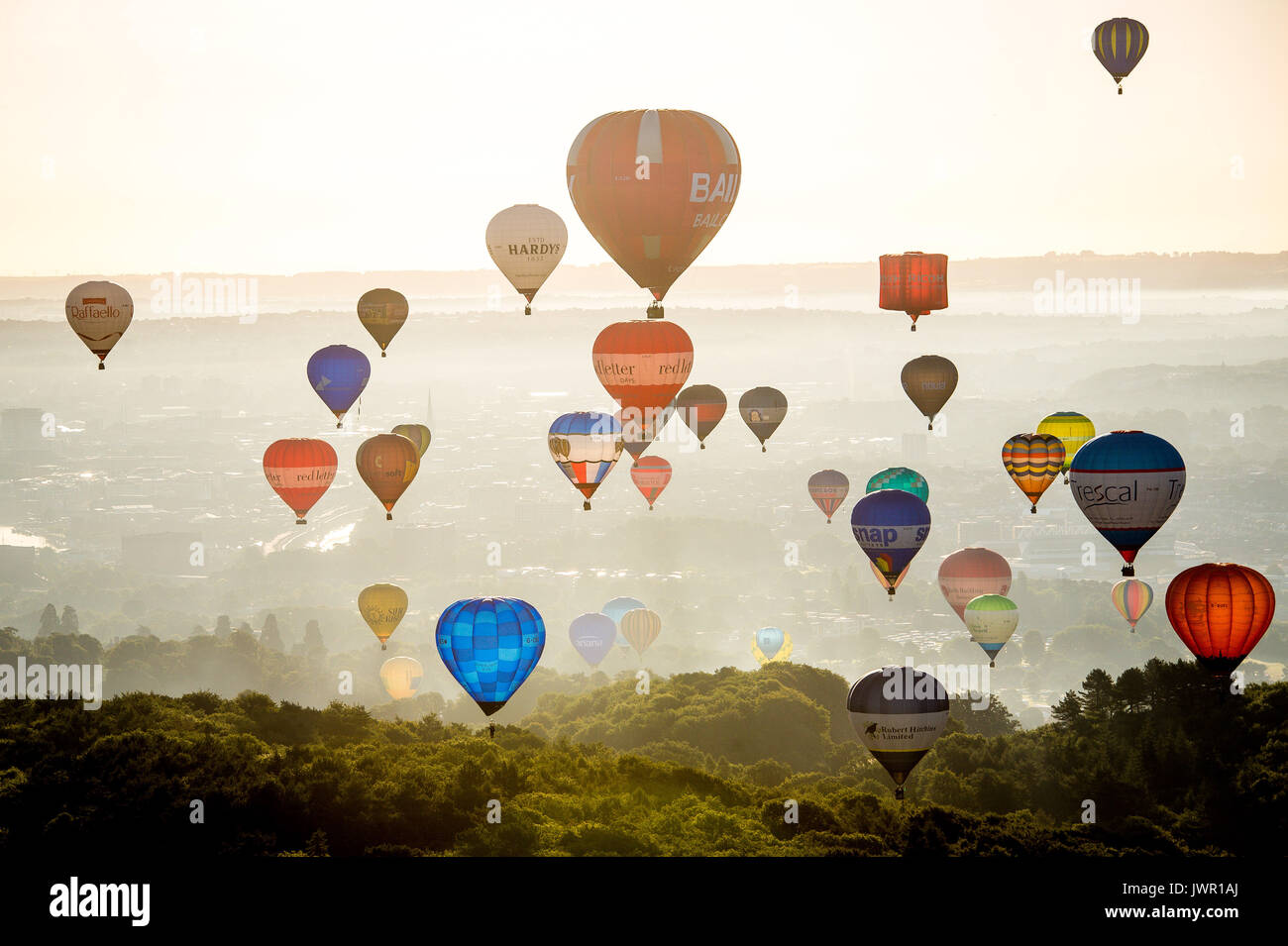 I palloni ad aria calda passa il puntatore del mouse su Long Ashton, Bristol, durante la salita di massa, dove mongolfiere provenienti da tutto il mondo si riuniranno a Ashton Court, Bristol, a prendere parte al Bristol International Balloon Fiesta. Foto Stock