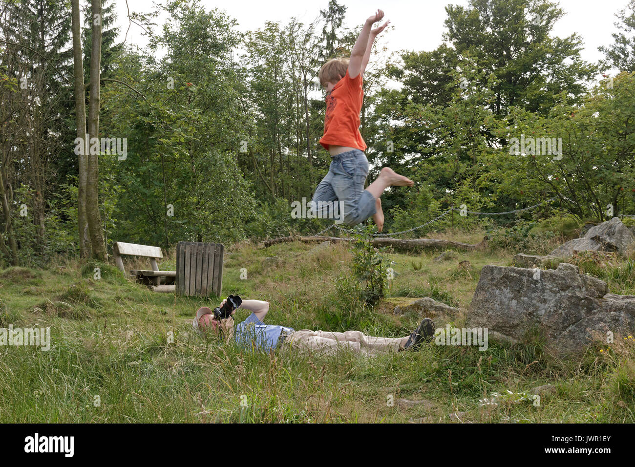 L'uomo prendendo la foto del ragazzo di salto Foto Stock