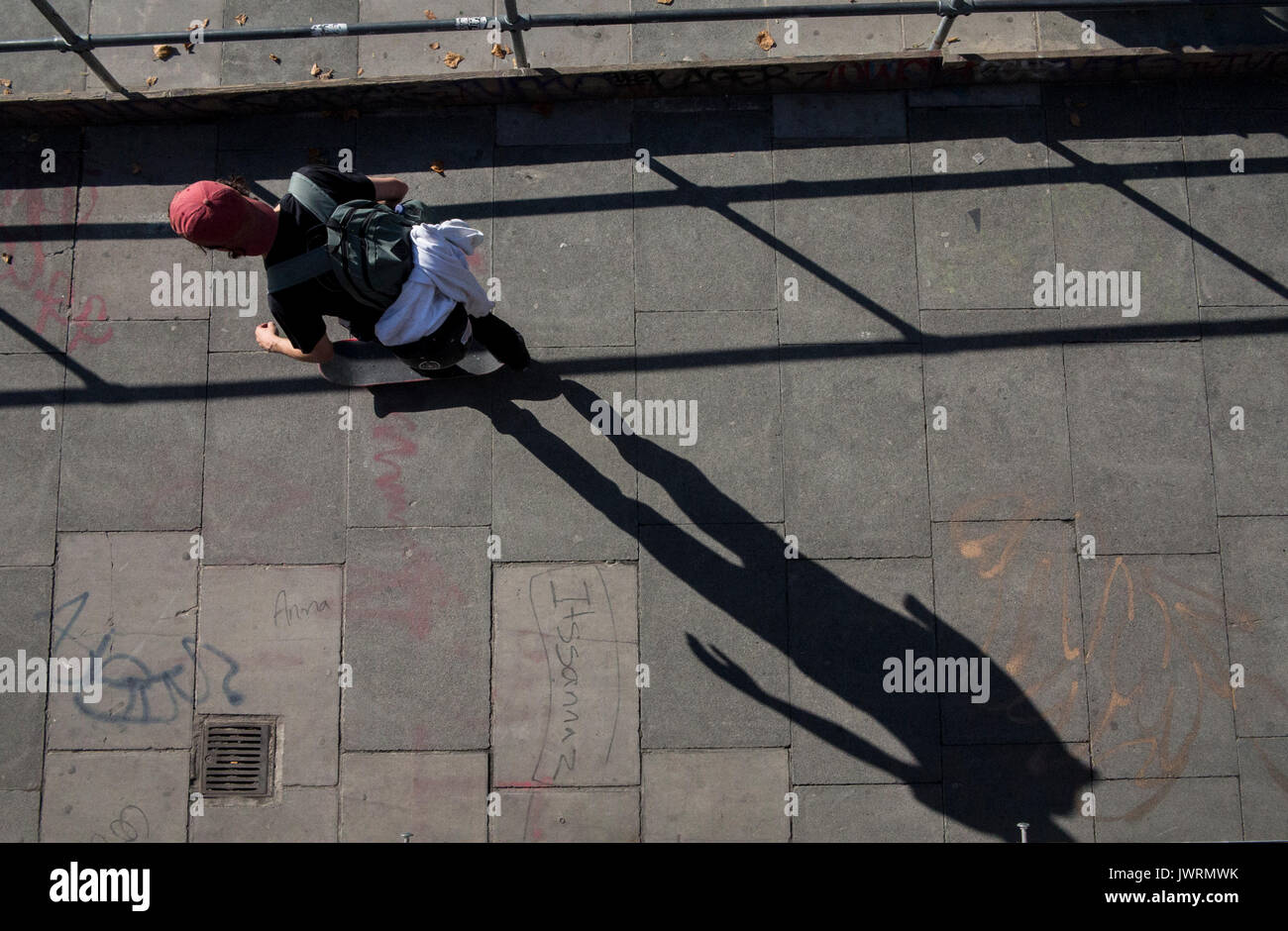 Lunghe ombre di un guidatore di skateboard, presa da sopra come egli commuta home Foto Stock