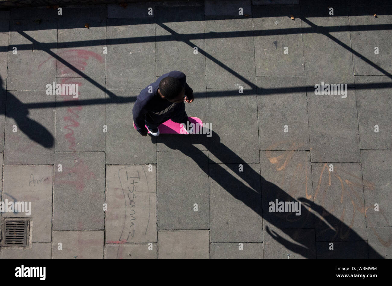 Lunghe ombre di un guidatore di skateboard, presa da sopra come egli commuta home Foto Stock