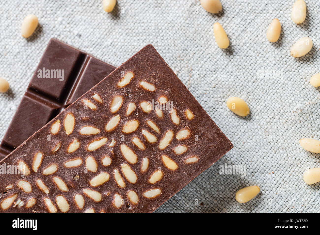 Barre di materie vegan cioccolato artigianale con semi di pino su tela dello sfondo. Concetto vegetariana di alimenti sani. Vista superiore Foto Stock