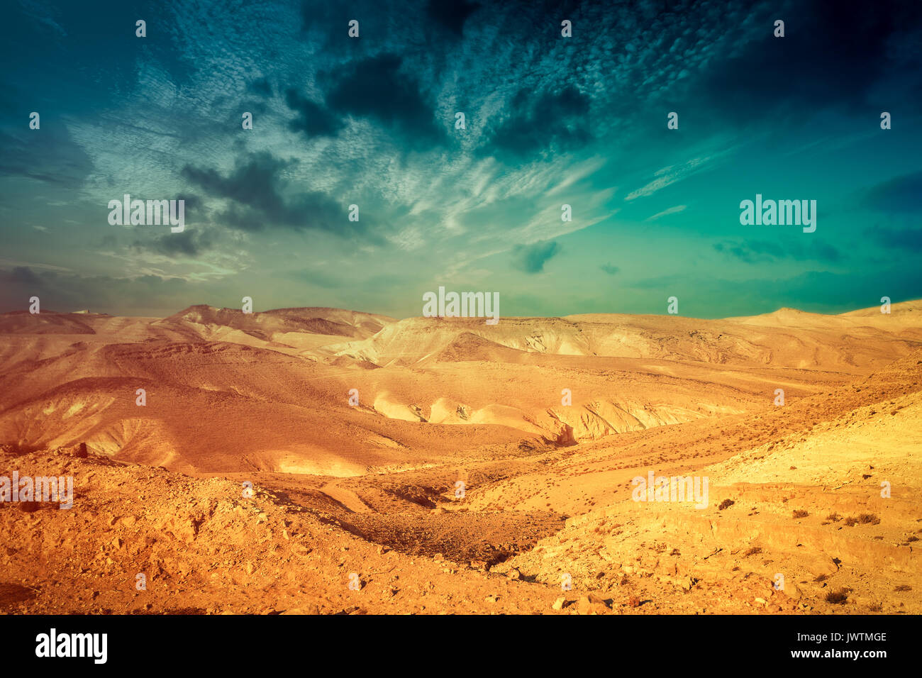 Deserto di montagna con colorati cielo nuvoloso. Deserto della Giudea in Israele al tramonto Foto Stock