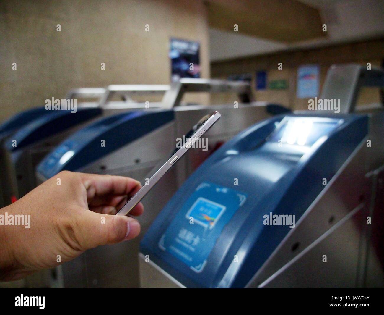 Pechino, Cina. 14 Ago, 2017. Un passeggero strisciate un cellulare in corrispondenza di una stazione della metropolitana di Pechino, capitale della Cina, 14 agosto 2017. I passeggeri possono semplicemente sfiorare i loro telefoni cellulari a bordo tutti di Pechino la linee di metropolitana a partire da lunedì, autorità locali detto. Secondo la metropolitana di Pechino, piloti compatibile con i modelli di telefono possono scaricare un'app per prendere la metropolitana e ricaricare le e-biglietti online. Attualmente, l'e-i biglietti sono limitati a circa 160 telefono Android modelli con tecnologia NFC (Near Field Communication) funzione. Credito: Du Jianpo/Xinhua/Alamy Live News Foto Stock