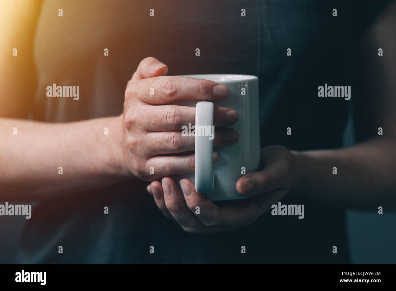Donna di bere il caffè al mattino, close up di mani femminili con tazza di caffè Foto Stock
