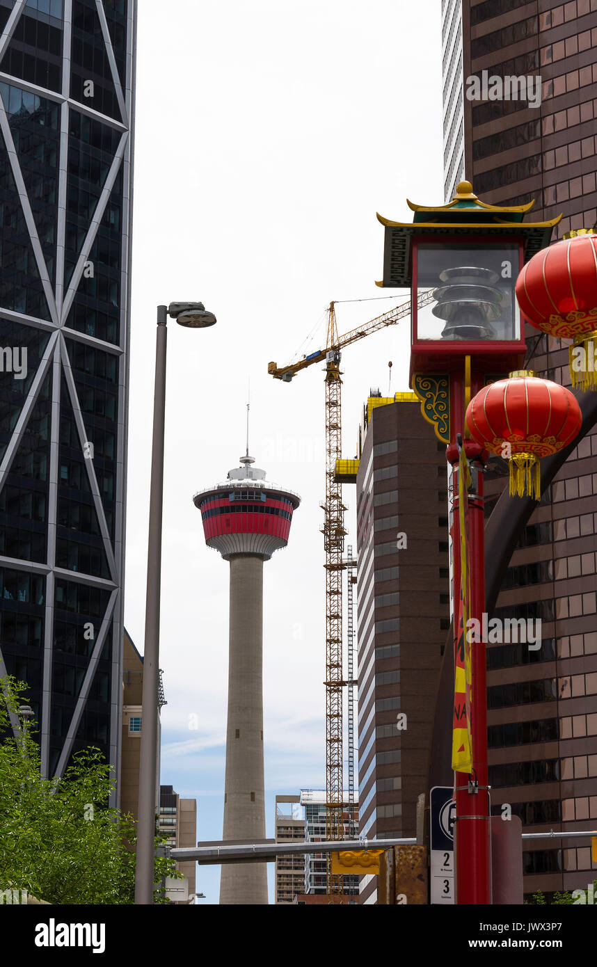 La Calgary Tower con lanterna cinese e grandi gru industriali da Chinatown Calgary Alberta Canada Foto Stock