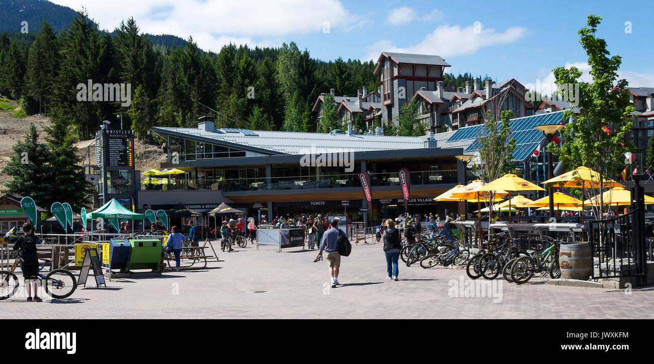 Gli amanti della mountain bike in abiti colorati nel rilassante bar e ristoranti in Whistler Resort Città della Columbia britannica in Canada Foto Stock