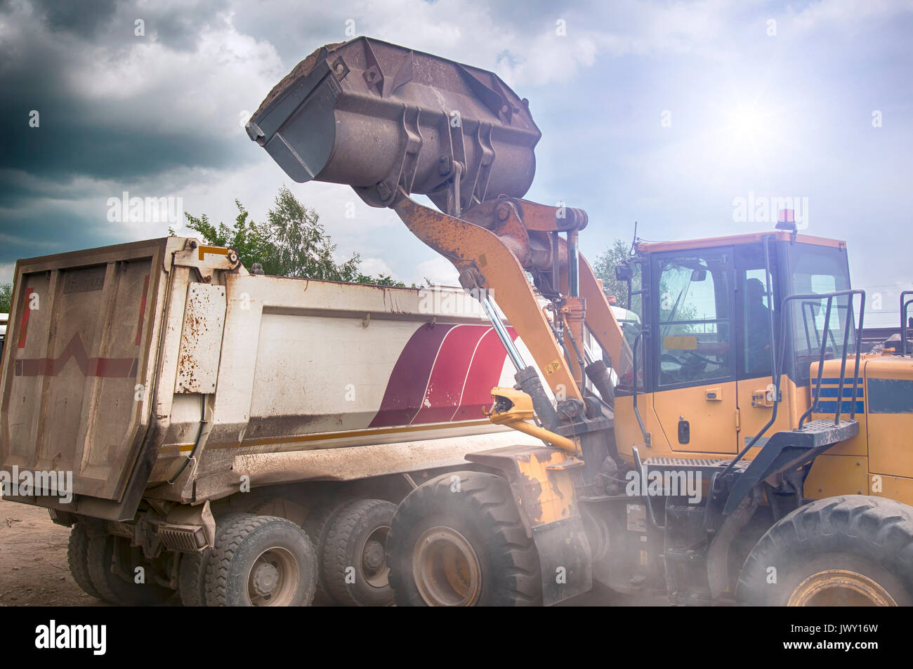 Carichi di escavatore ghiaia nel carrello Foto Stock