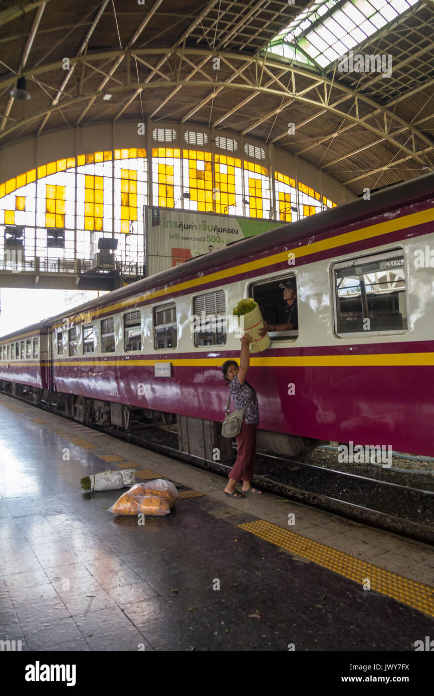 Persone caricamento pacchi attraverso la finestra su un treno, Hua Lamphong stazione ferroviaria, Bangkok, Thailandia Foto Stock