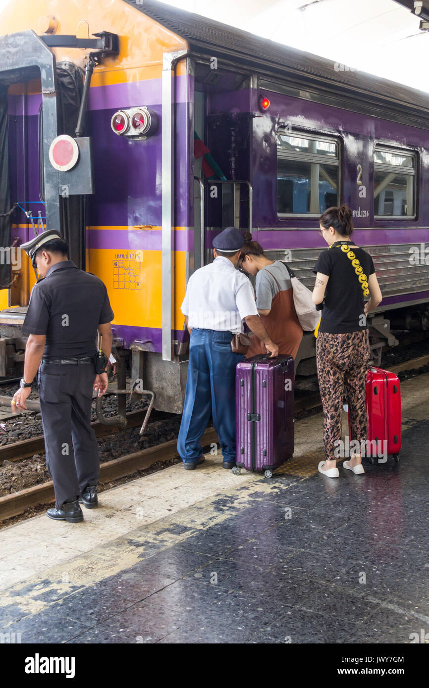 I passeggeri di essere assistito da personale a bordo di un treno, Hua Lamphong stazione ferroviaria, Bangkok, Thailandia Foto Stock