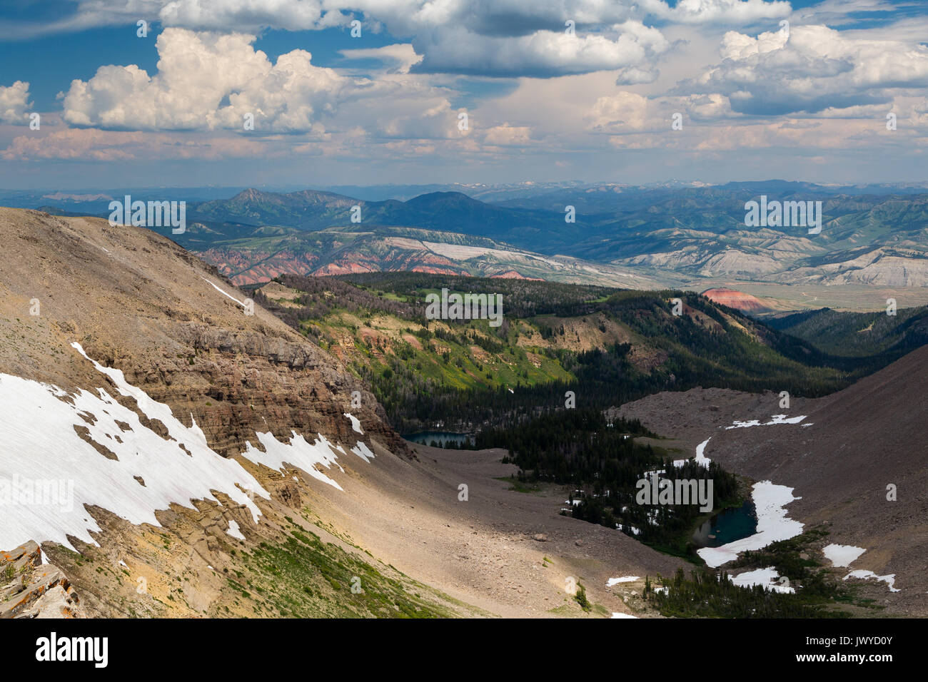 Avanzi di neve dalla stagione invernale aggrappati alle scogliere e rocce blu sopra il minatore lago sotto la cima del sonno indiano del Gros Ventre Mou Foto Stock