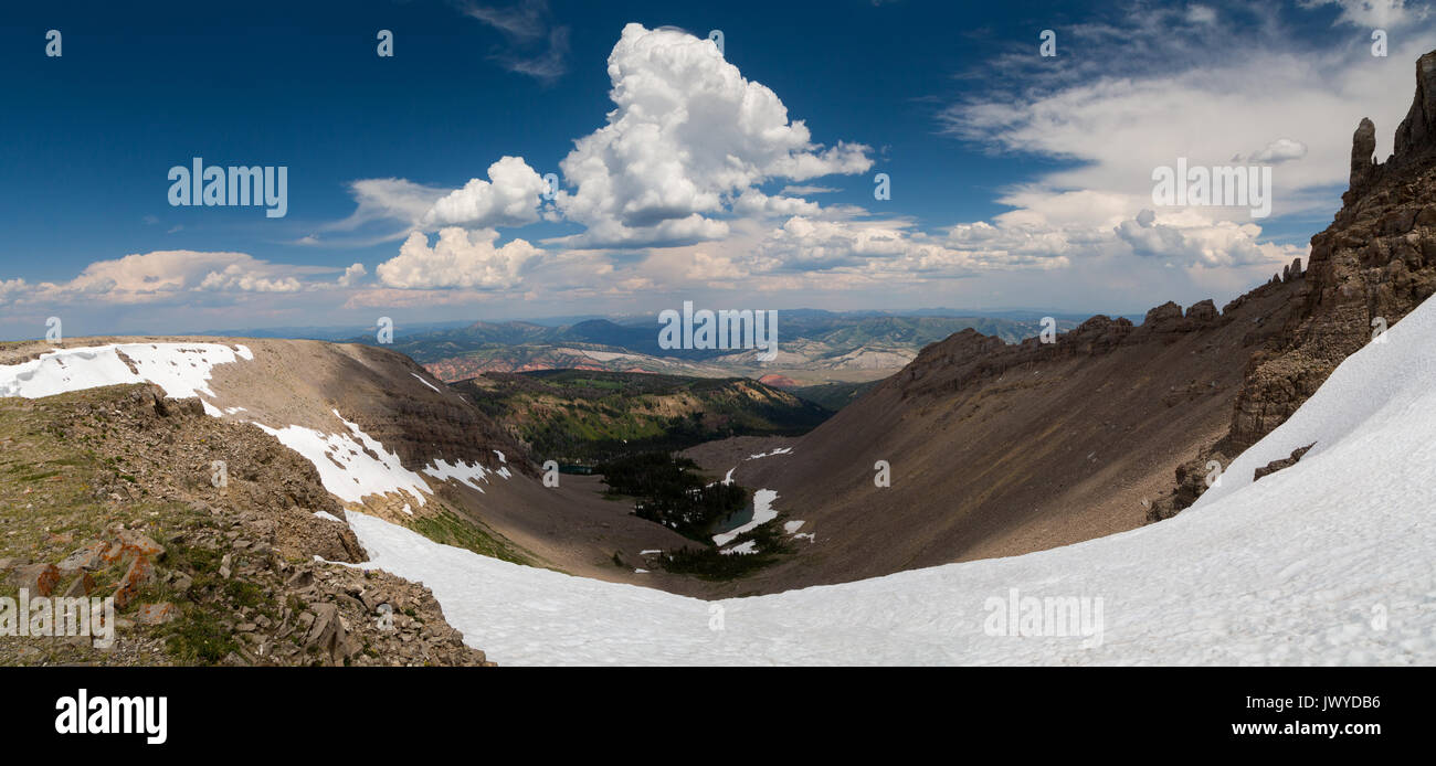 Un grande snow bank aggrappati alle rocce e dirupi sotto la cima del sonno indiano del Gros Ventre montagne. Gros Ventre deserto, Wyoming Foto Stock