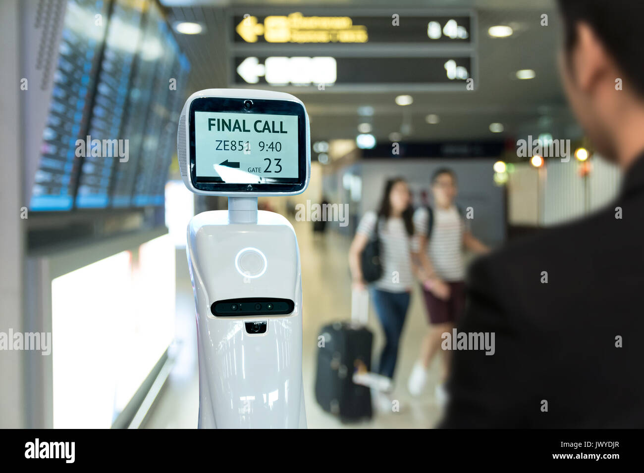 Imprenditore suit passeggeri devono utilizzare auto chcek guida-nei robot assistente per biglietto e accompagnarli alla loro porta all aeroporto internazionale. Foto Stock