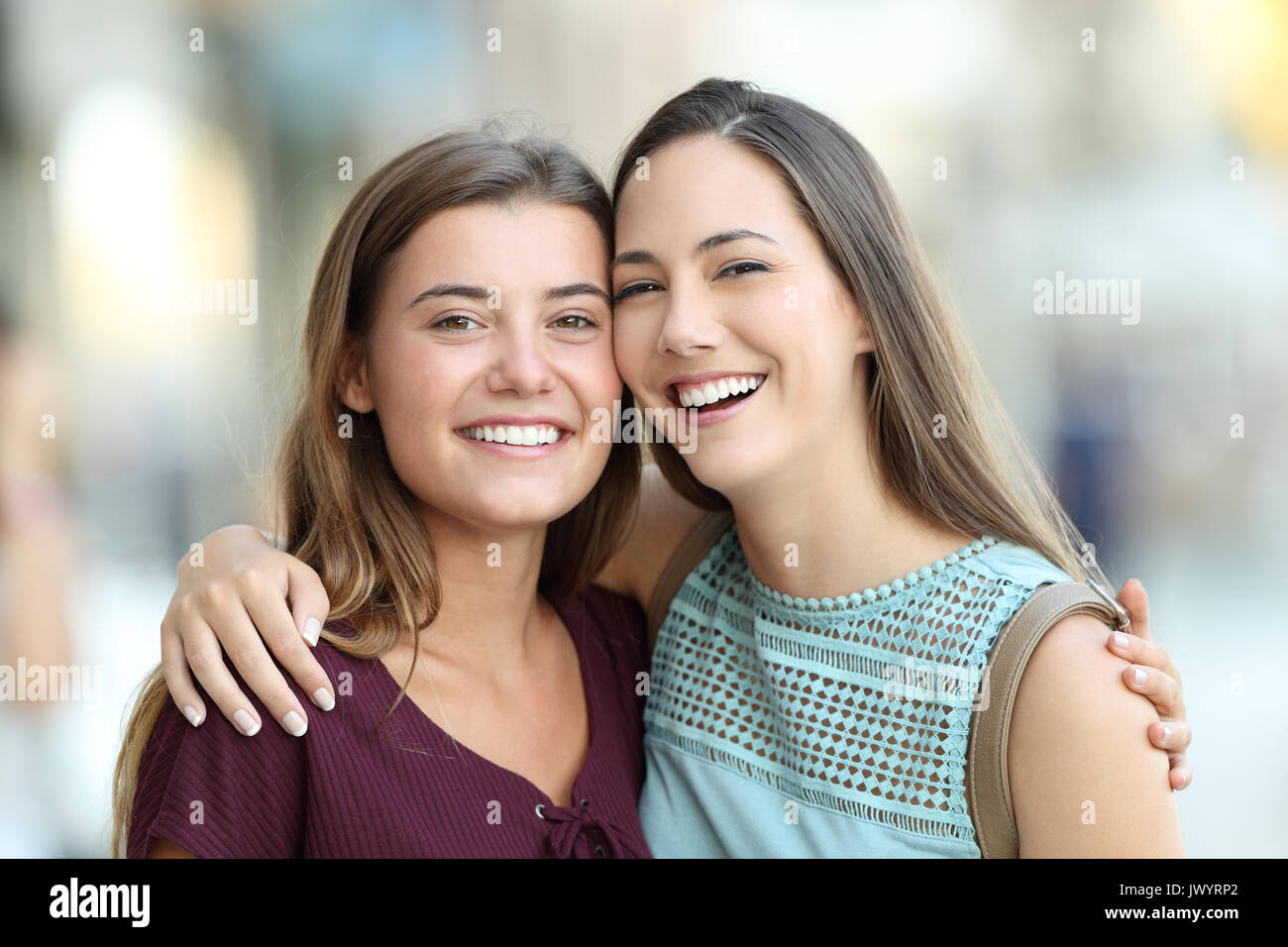 Due amici in posa con perfetta sorrisi e guardando la fotocamera su strada Foto Stock