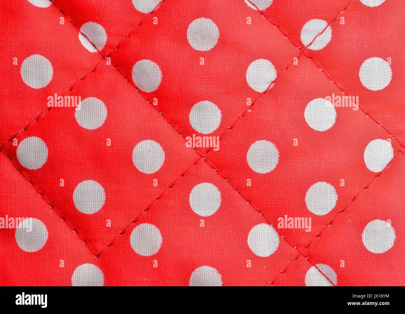 Colpo di sfondo di un rosso polka dot tela con cuciture. Foto Stock