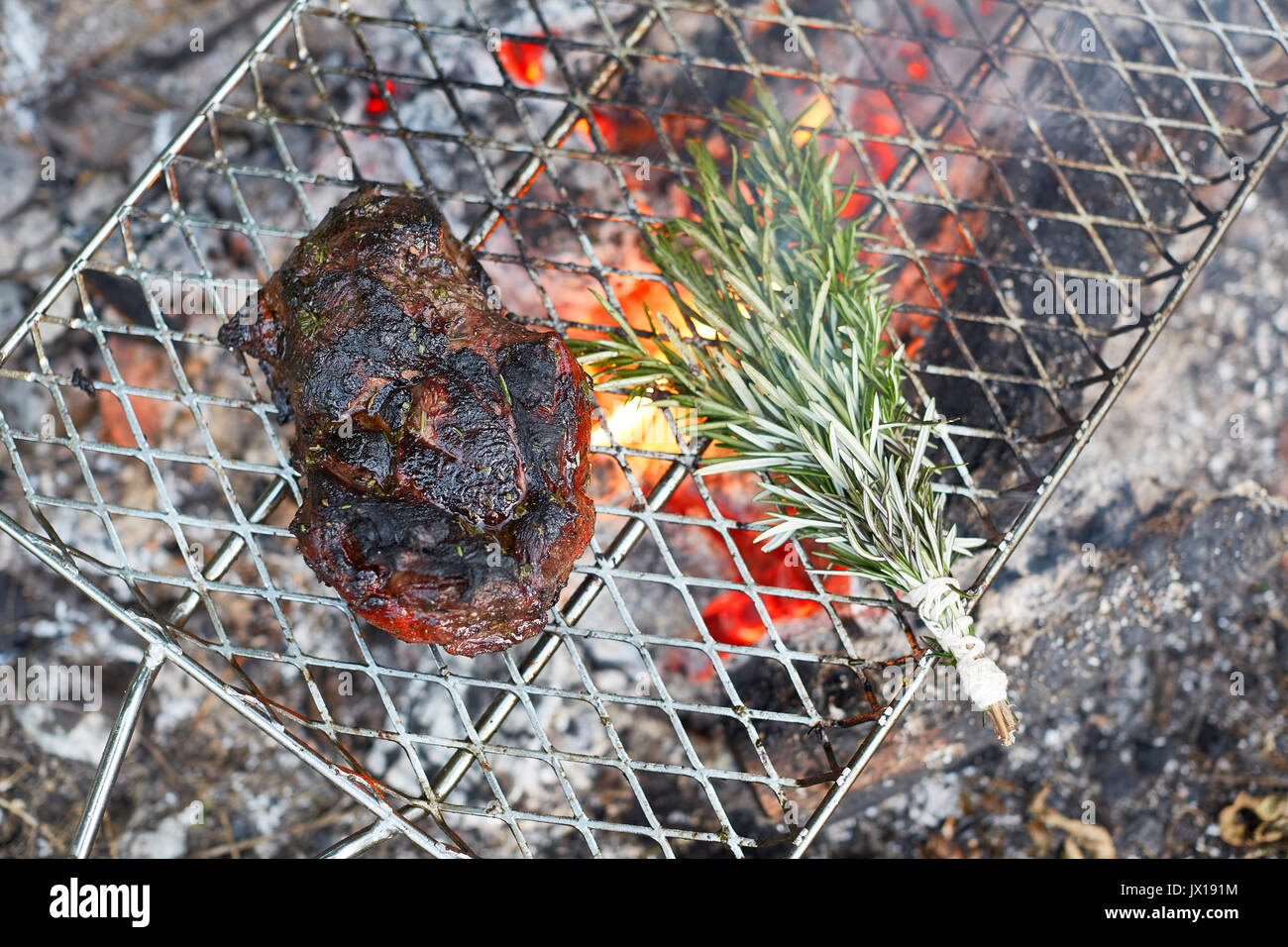 Agnello alla griglia e rosmarino su camp grill Foto Stock