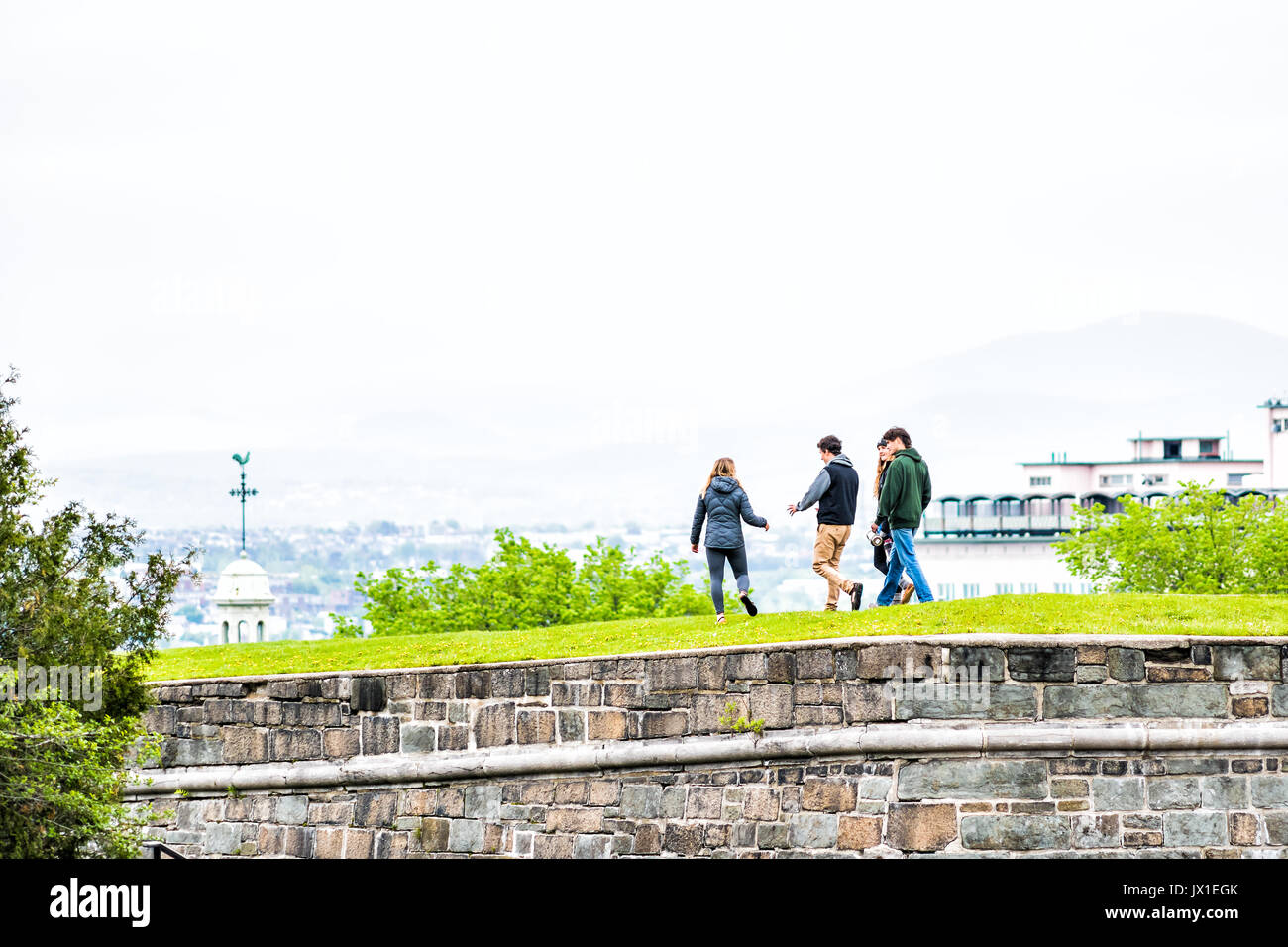 La città di Quebec, Canada - 29 Maggio 2017: un gruppo di giovani a piedi sulla cima di erba verde campi nel parco con fortificazioni muro di pietra Foto Stock