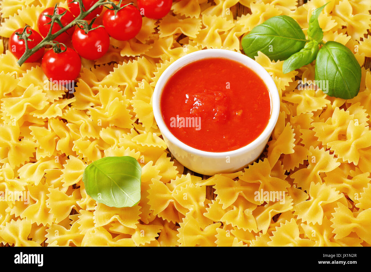 Non cotti bow tie pasta con salsa di pomodoro Foto Stock