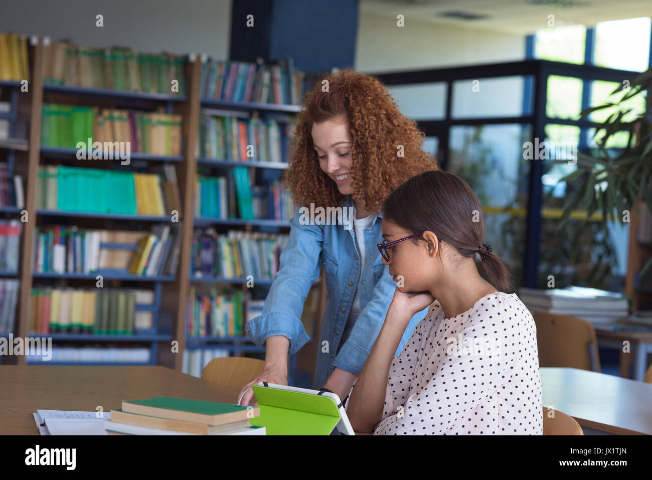 Studenti di sesso femminile a discutere al banco in aula Foto Stock