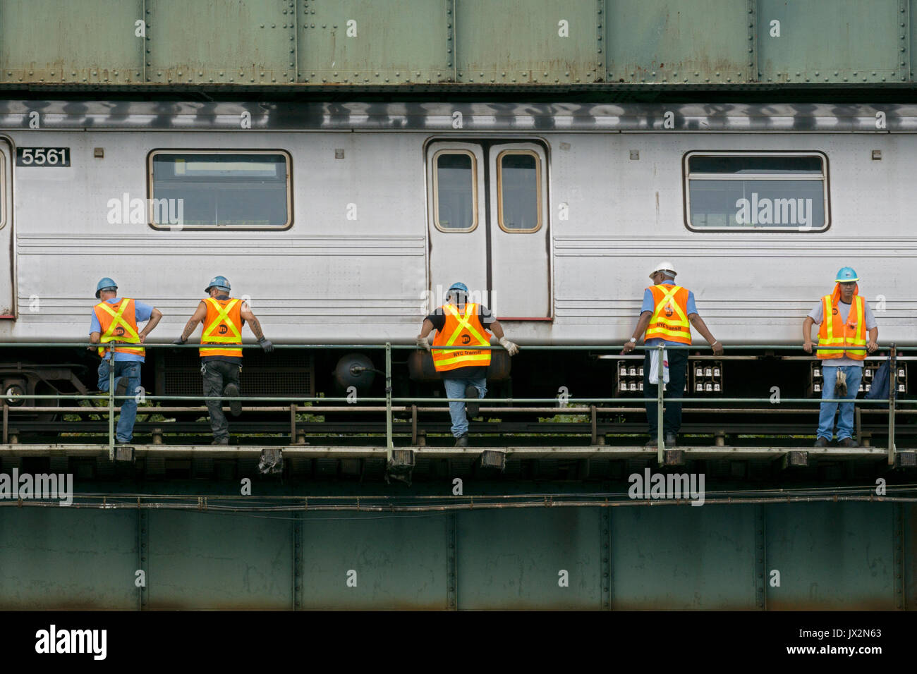 New York City MTA lavoratori in giubbotti di sicurezza un lavoro una passerella elevata vicino alla metropolitana brani di Coney Island, Brooklyn, New York City. Foto Stock