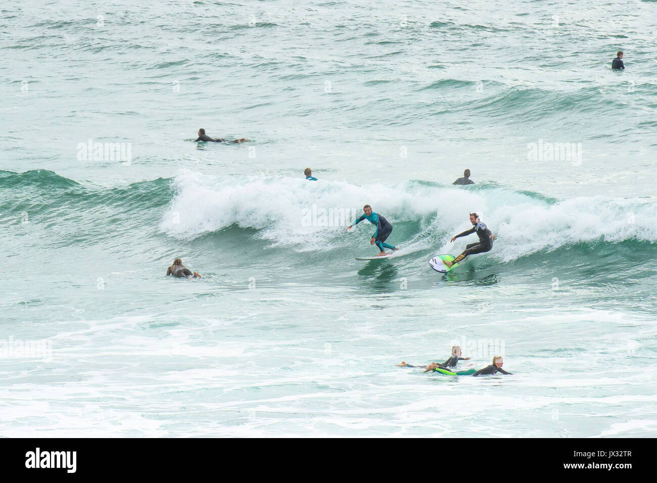 Navigare in UK. Surfisti cavalcare un onda a Fistral in Newquay, Cornwall. Foto Stock