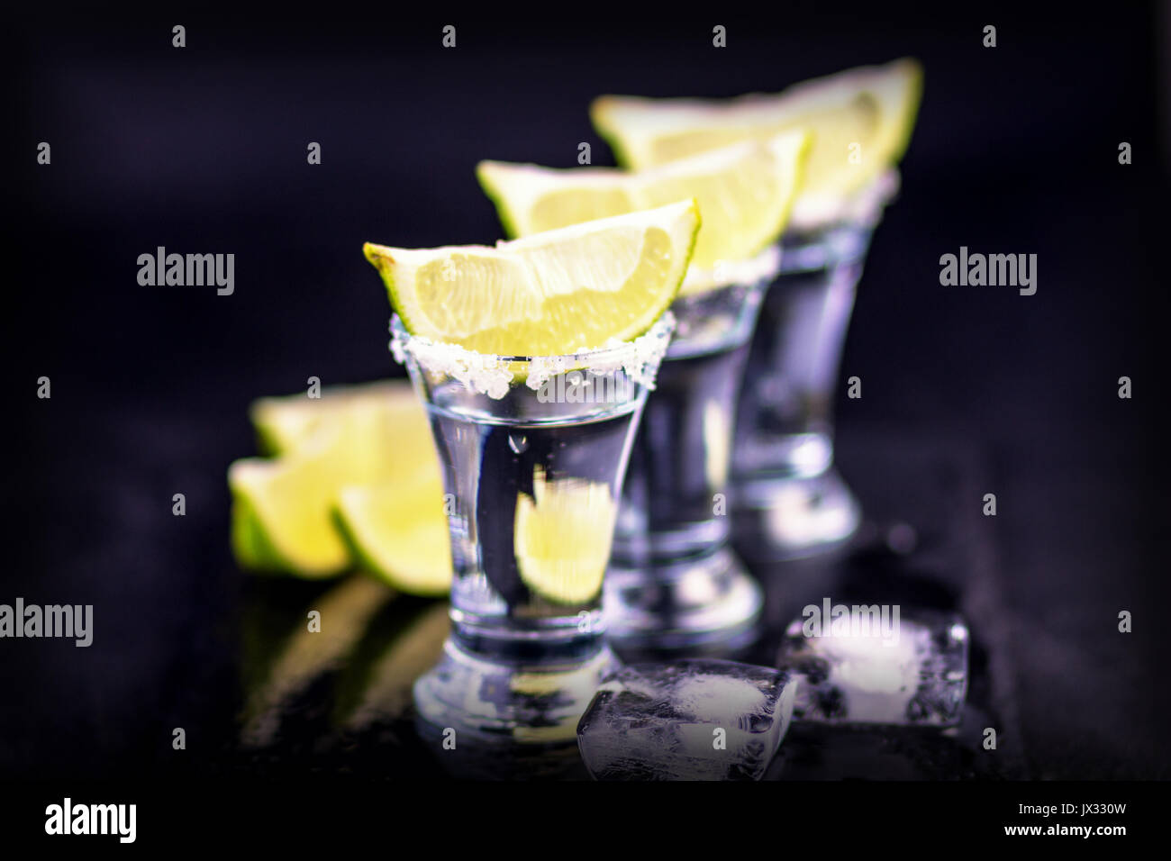 Argento tequila messicana scatti con sale e calce al buio su un sfondo di ardesia. Close-up. Tequila. Tequila shot. Foto Stock