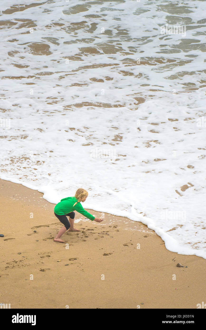 Una giovane ragazza che gioca al mare in Cornovaglia. Foto Stock