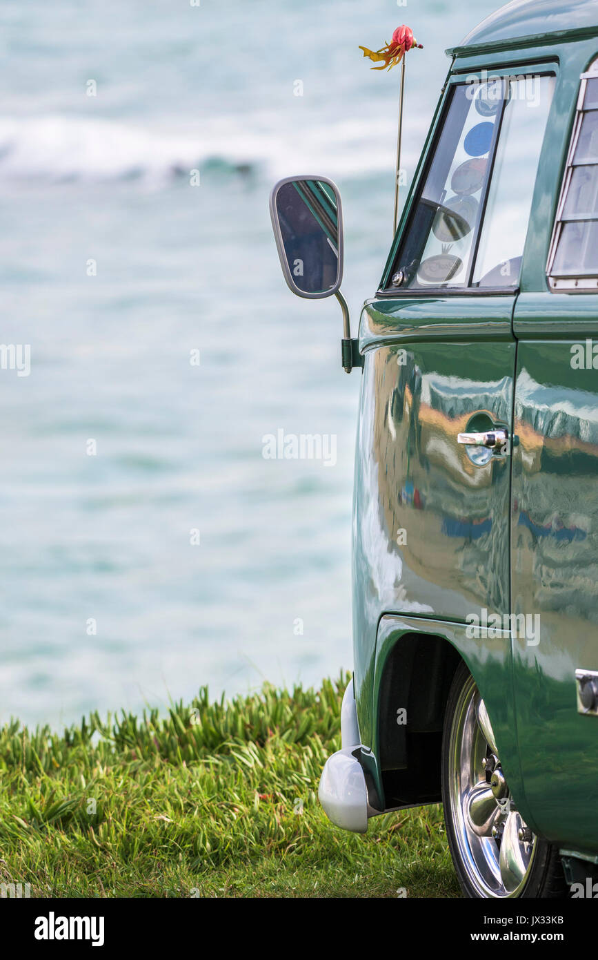 Dello specchietto retrovisore sul lato di un vintage VW camper parcheggiato affacciato sul mare. Foto Stock