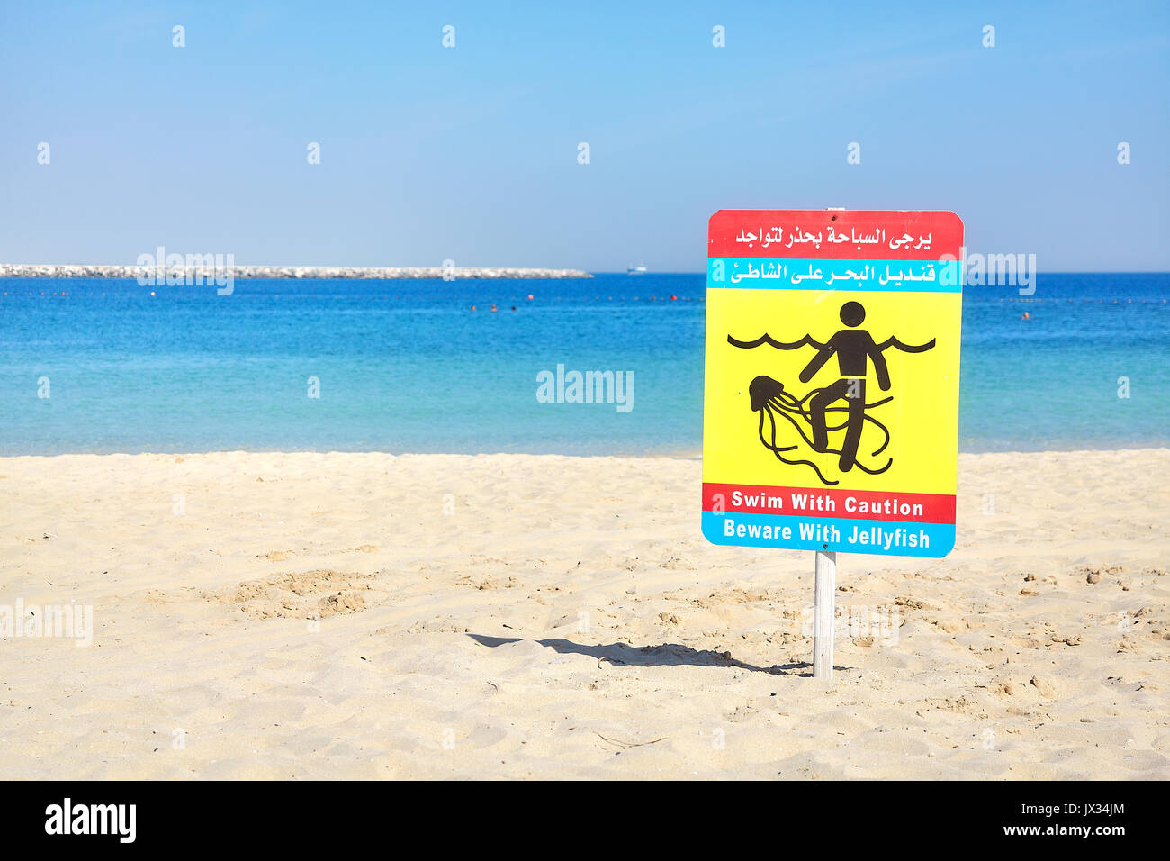 Fate attenzione con le meduse cartello segnaletico su una spiaggia in Dubai Emirati Arabi Uniti. Foto Stock