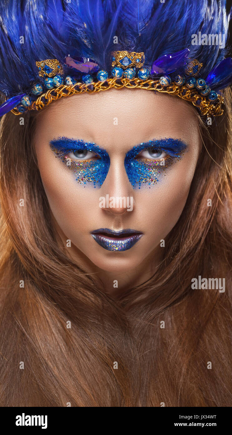 Il trucco di moda in American stile indiano. Donna attraente con il make-up con blu brillante di piume Foto Stock