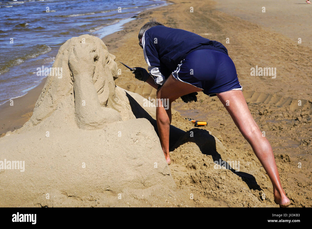 Artista realizza una scultura di sabbia di una sirena. Fotografato a Jurmala, Lettonia Foto Stock