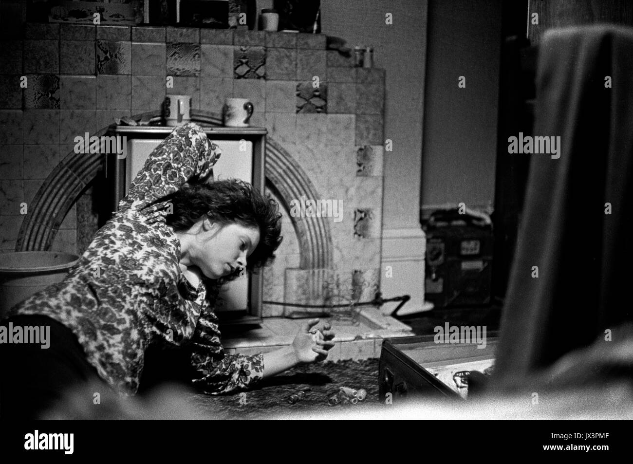 Accomodatevi in 1971 piccole camere con una stanza, Londra anni '1970, giovane donna che si asciuga i capelli di fronte a un fuoco a gas. UK HOMER SYKES Foto Stock