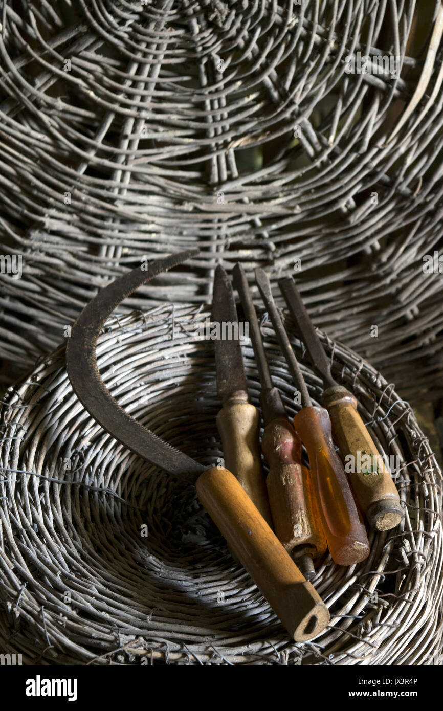 Vecchi strumenti rurali su un round cesto in vimini come sfondo Foto Stock