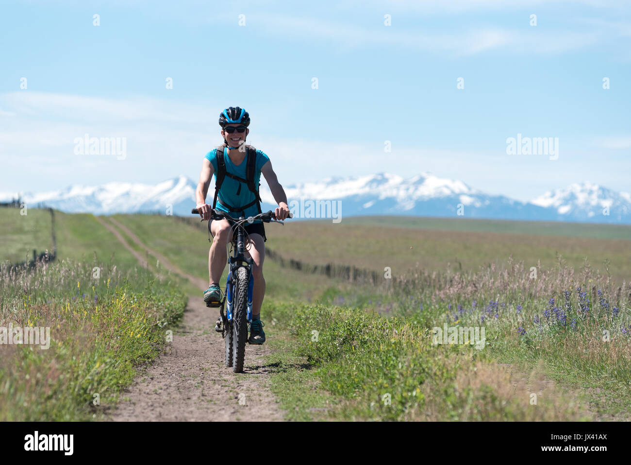 Woman Mountain bike una strada sulla Zumwalt Prairie nella zona nord-est di Oregon. Foto Stock