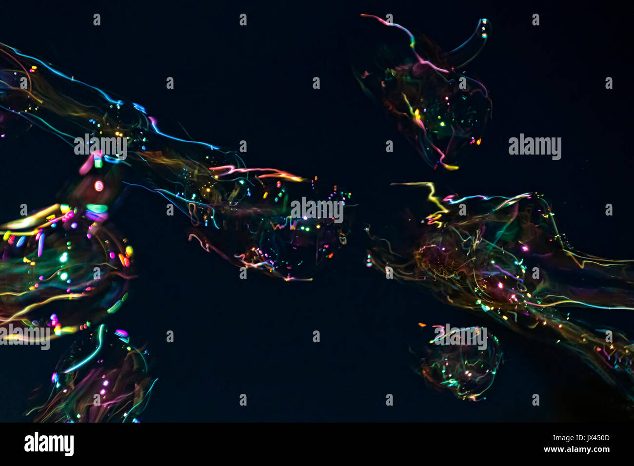 Ventilatore della bolla fa bolle di sapone contro il cielo nero lo sfondo Foto Stock