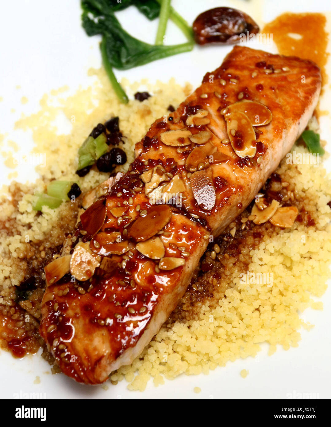 Vetrata di filetto di salmone coperto con mandorle e salsa teriyaki su un letto di cuscus Foto Stock