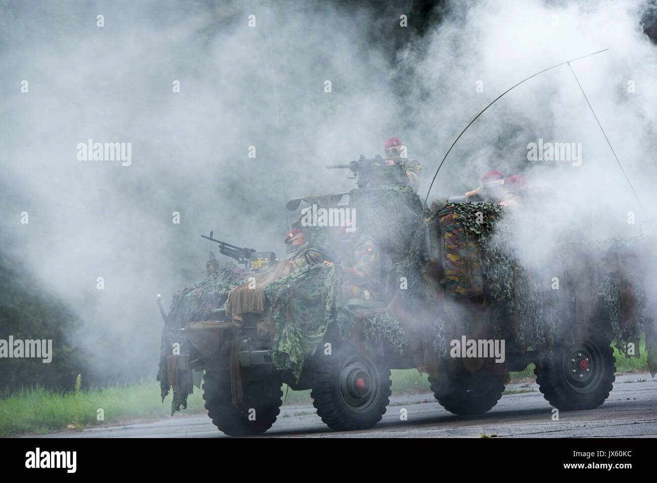 Schermo di fumo e paracommandos belgi del reggimento Para-Commando sotto attacco in mimetizzata LRPV veicolo blindato, la Mercedes-Benz Unimog 404 Foto Stock