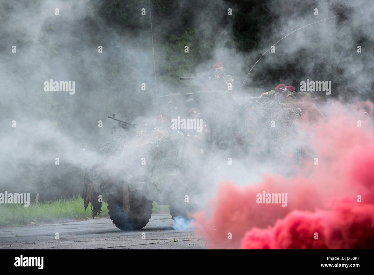Schermo di fumo e paracommandos belgi del reggimento Para-Commando sotto attacco in mimetizzata LRPV veicolo blindato, la Mercedes-Benz Unimog 404 Foto Stock