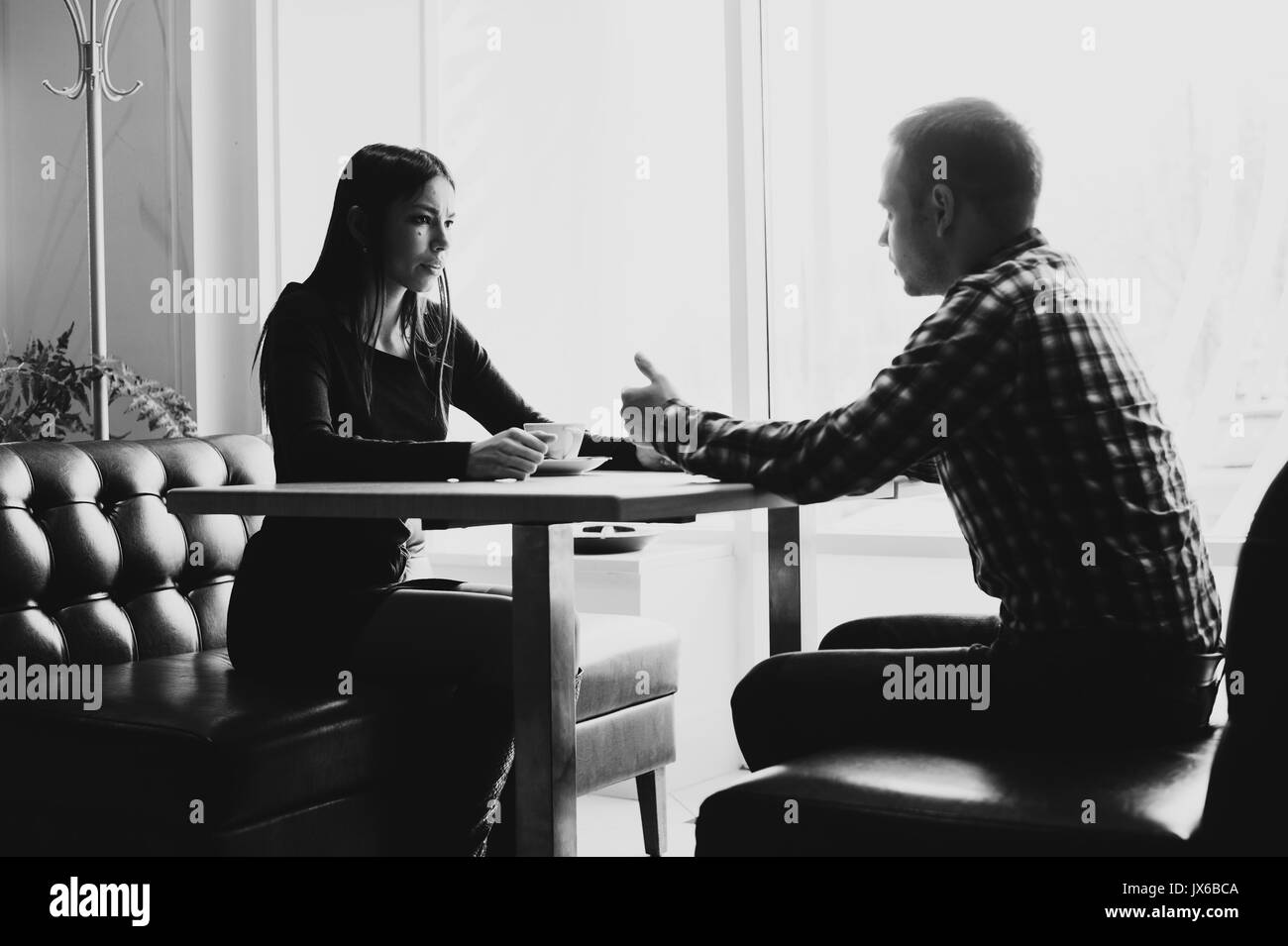 Scena in cafe - giovane conflitto sostenendo durante il pranzo. Foto Stock