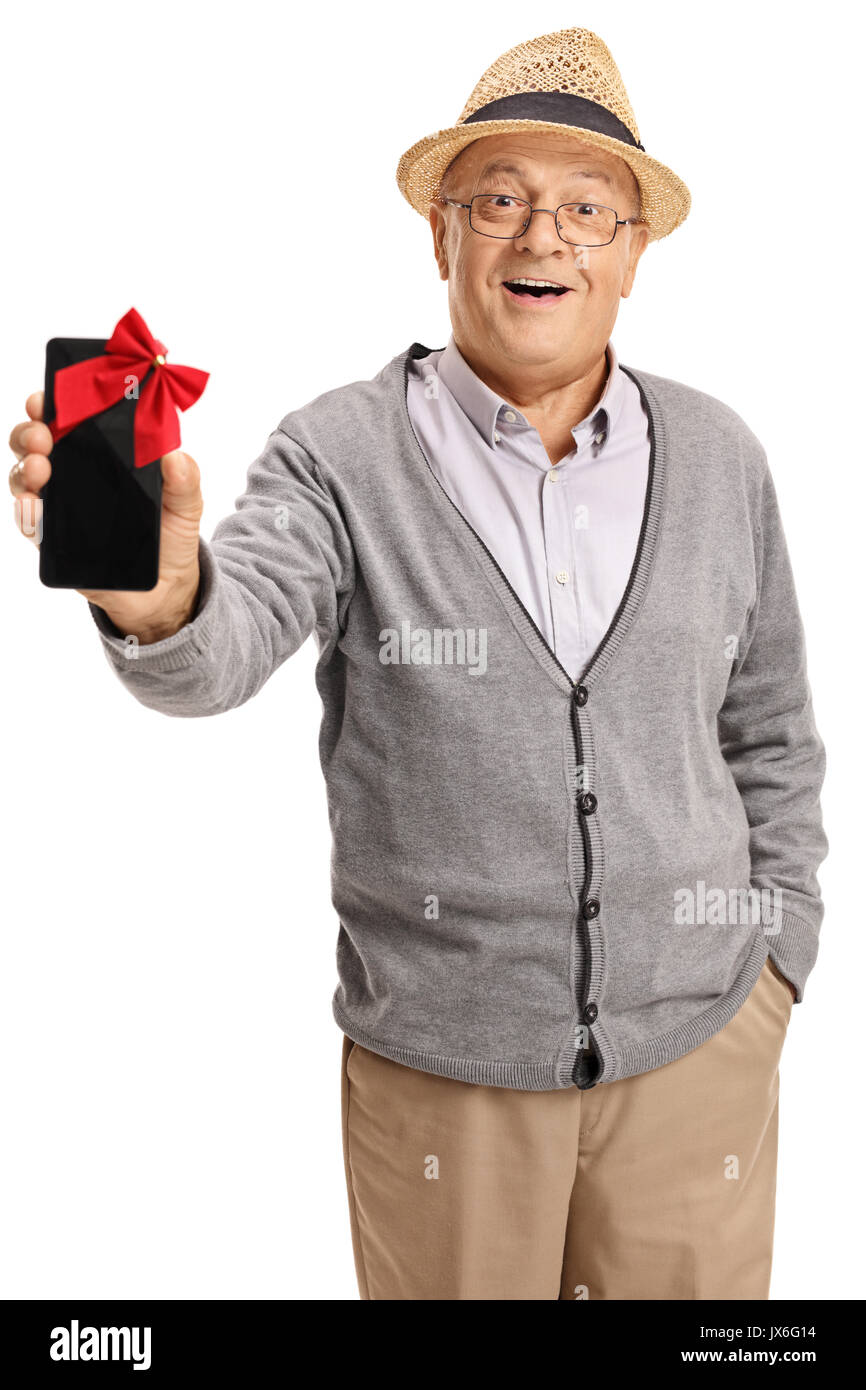 Uomo maturo che mostra un telefono avvolto con un nastro rosso come un presente isolato su sfondo bianco Foto Stock