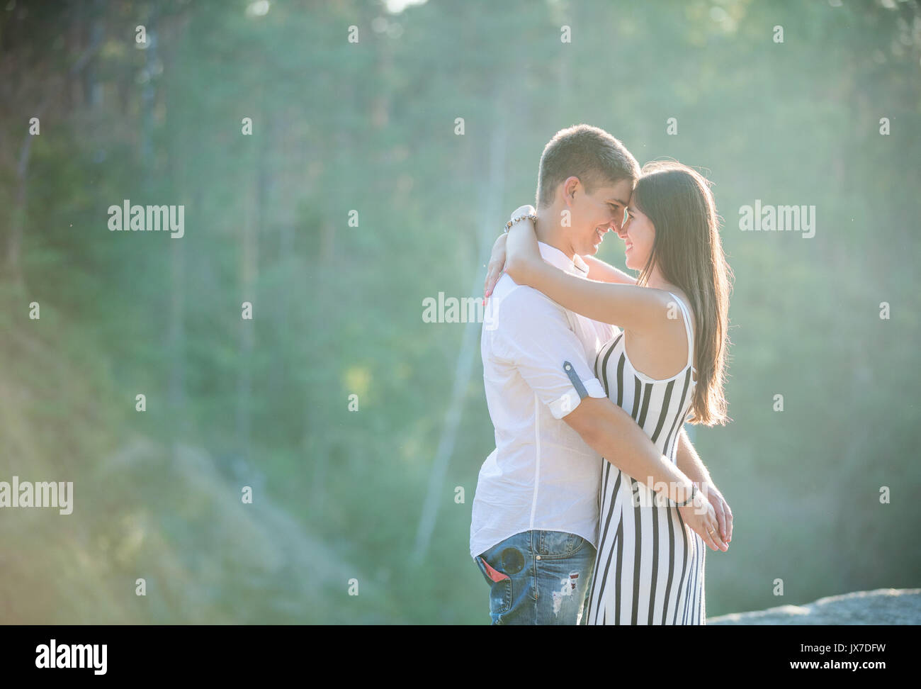 Felice coppia giovane kissing all'aperto sul giorno di estate Foto Stock