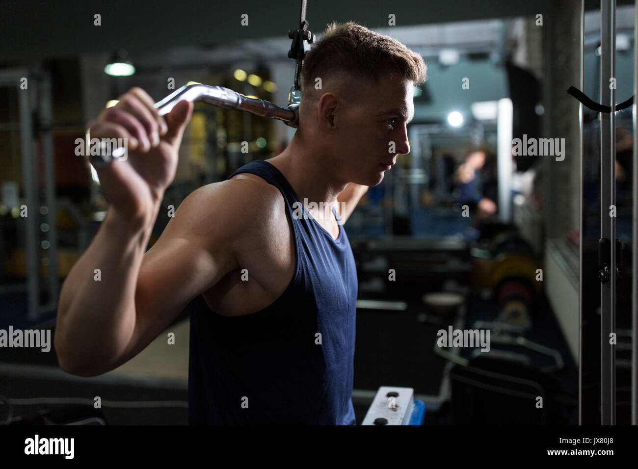 Uomo muscoli di flessione sul cavo macchina in palestra Foto Stock