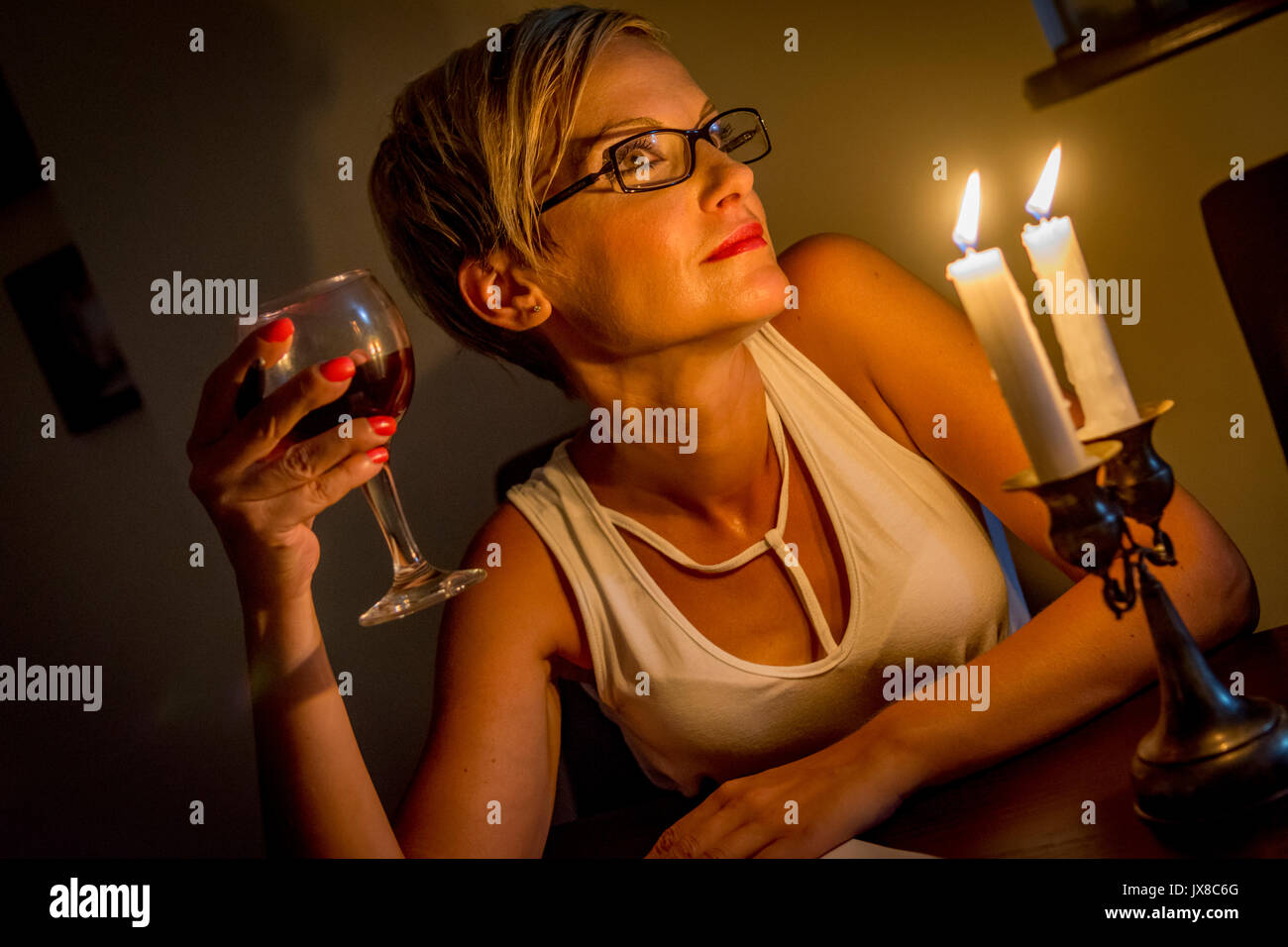 Donna celebra con un bicchiere di vino rosso Foto Stock