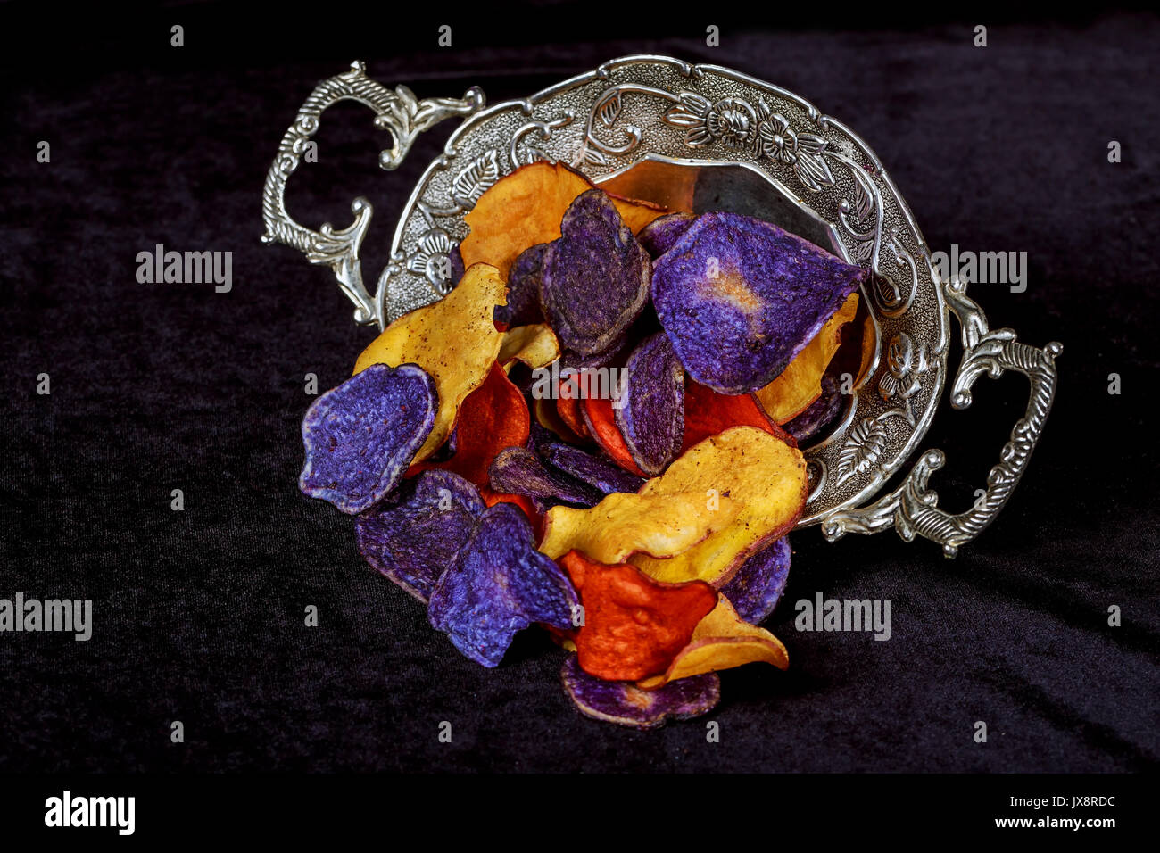 Antipasto croccante di patatine in rosso, bianco e blu in una ciotola di vetro su un tavolo. Foto Stock