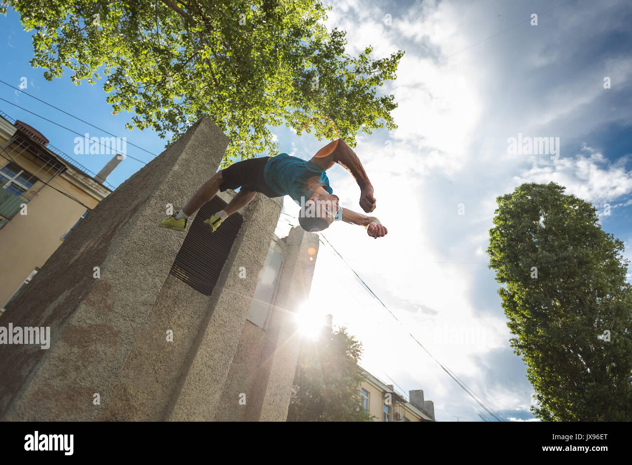 Città parkour. Il ragazzo non il contrario somersault. Le riprese dall'angolo inferiore. La destrezza ed estreme. Foto Stock